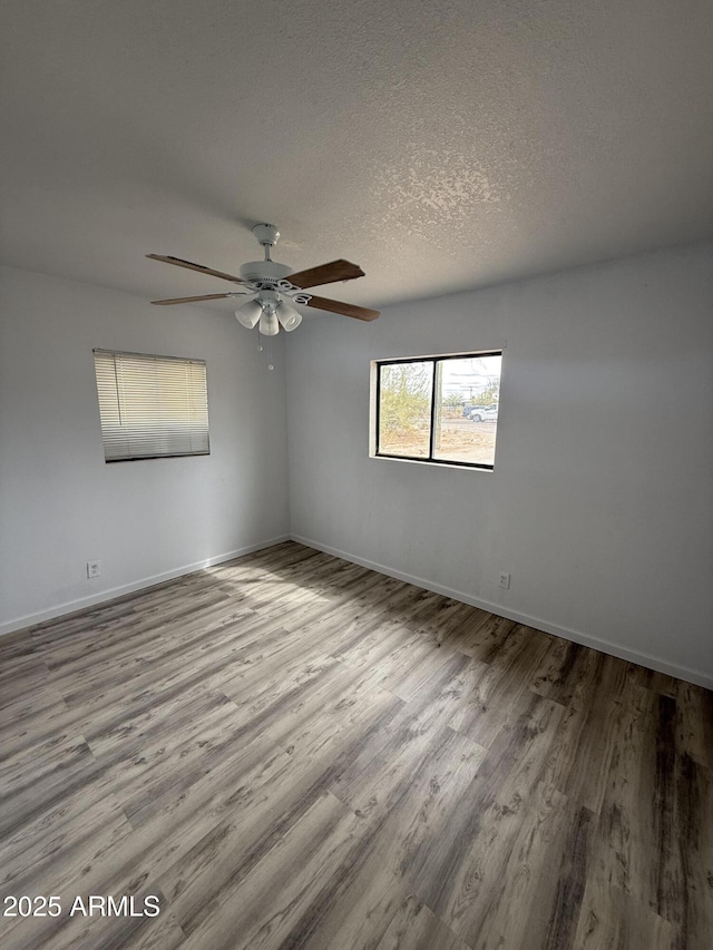 1020 W Schwartz Rd, Ajo, AZ 85321 - empty room featuring a ceiling fan, wood finished floors, baseboards, and a textured ceiling