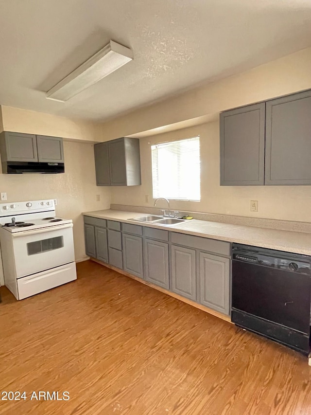 kitchen featuring white electric stove, a sink, gray cabinetry, black dishwasher, and under cabinet range hood