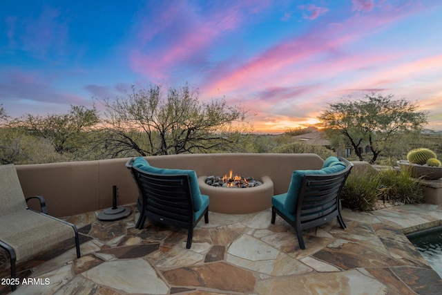 patio terrace at dusk featuring a fire pit