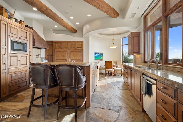 kitchen featuring a kitchen breakfast bar, a center island, built in microwave, decorative light fixtures, and stainless steel dishwasher