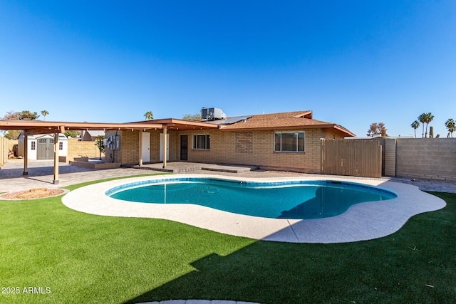 view of pool with central AC, a storage unit, a patio area, and a yard