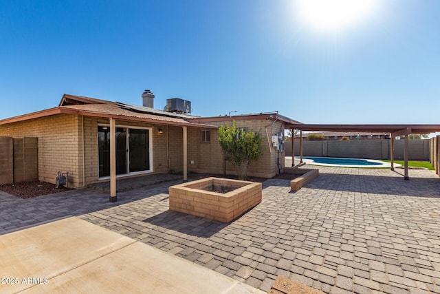 view of patio with an outdoor fire pit, a fenced in pool, and central air condition unit