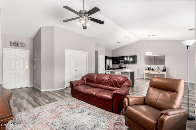 living room featuring dark wood-type flooring, ceiling fan, high vaulted ceiling, and baseboards