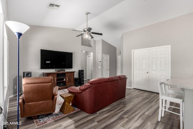 living room featuring a ceiling fan, visible vents, wood finished floors, and baseboards