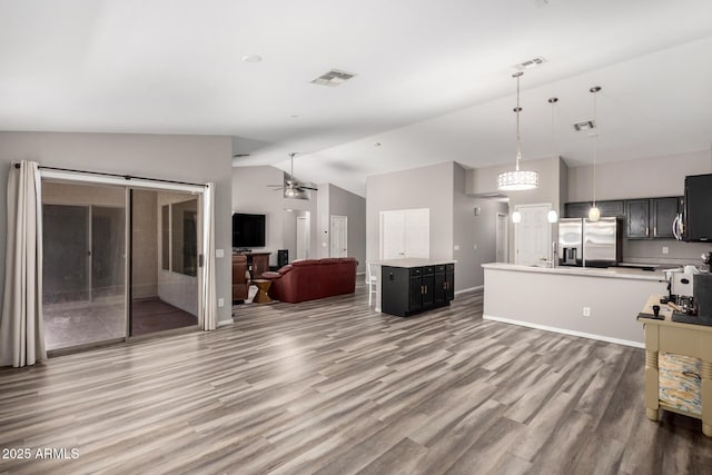 unfurnished living room with visible vents, baseboards, wood finished floors, a ceiling fan, and high vaulted ceiling
