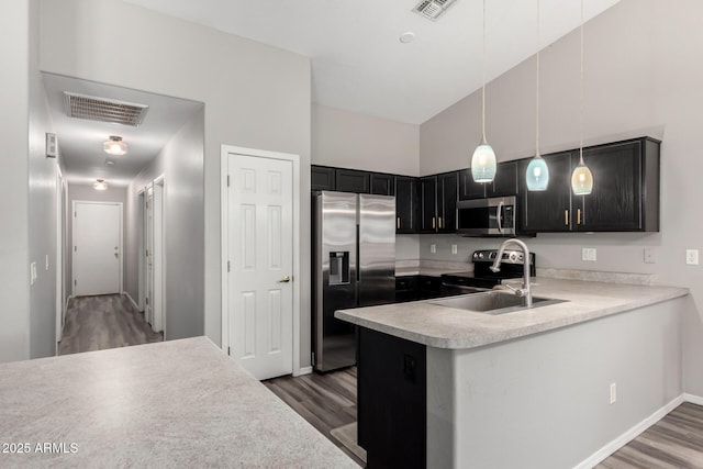 kitchen with wood finished floors, visible vents, stainless steel appliances, and a sink