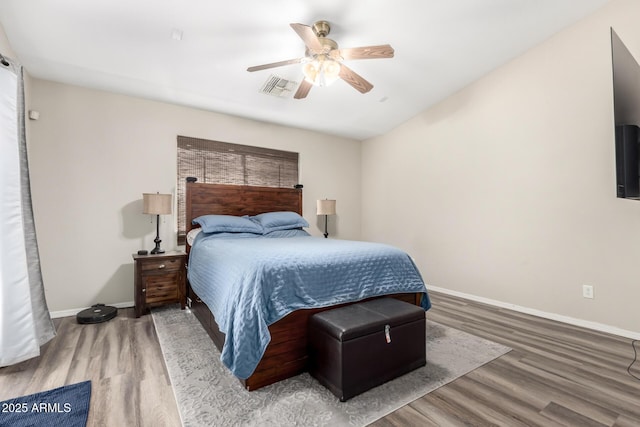 bedroom with baseboards, visible vents, and wood finished floors