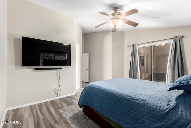 bedroom featuring a ceiling fan, access to outside, wood finished floors, and baseboards