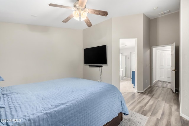 bedroom with light wood-style flooring, ensuite bathroom, baseboards, visible vents, and a ceiling fan