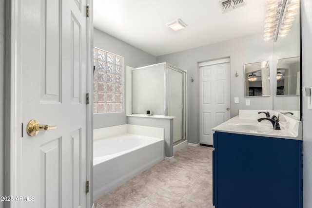 bathroom featuring a sink, a stall shower, visible vents, double vanity, and a garden tub