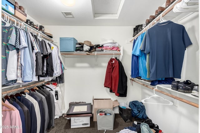 walk in closet featuring attic access, visible vents, and carpet