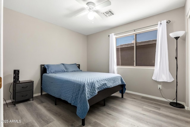 bedroom featuring wood finished floors, visible vents, ceiling fan, and baseboards