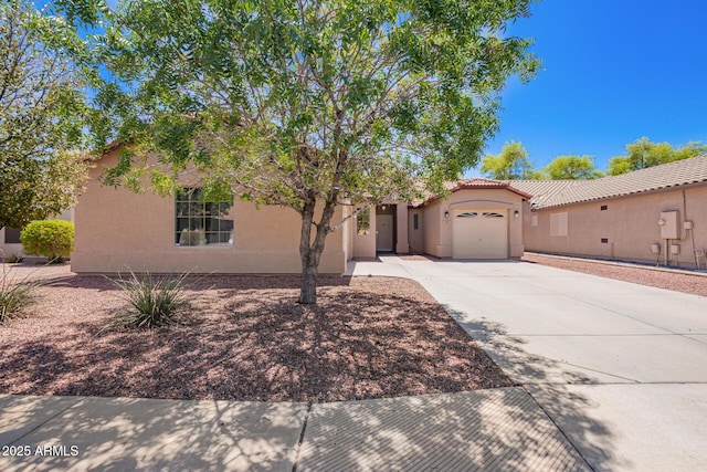 view of front of home featuring a garage, a tile roof, stucco siding, and driveway
