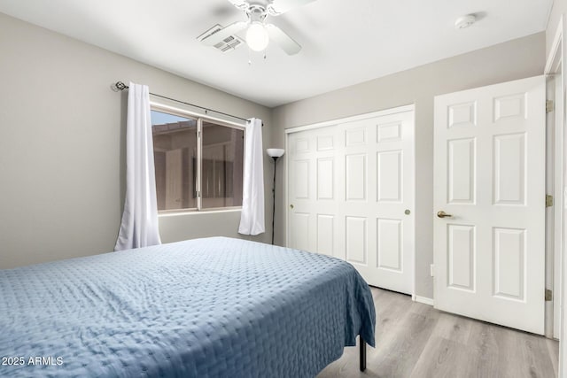 bedroom featuring visible vents, a ceiling fan, a closet, and light wood-style flooring