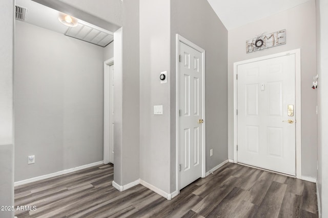 entryway with baseboards, visible vents, and dark wood-type flooring