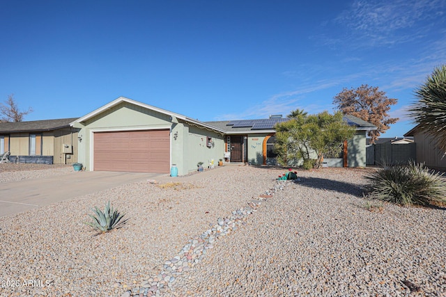 ranch-style house featuring a garage and solar panels