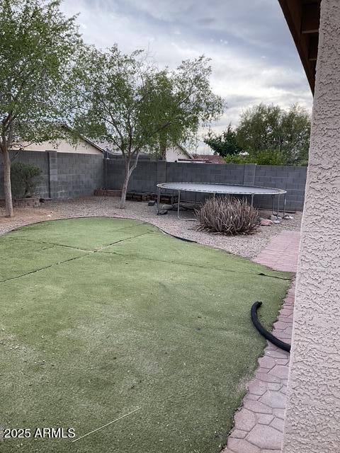 fenced backyard with a trampoline