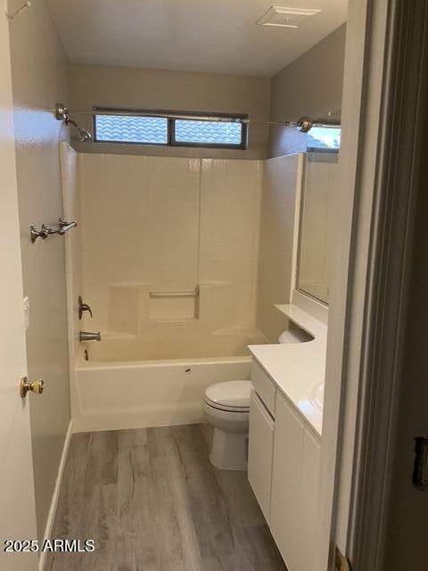 full bathroom with wood finished floors, toilet, vanity, and bathing tub / shower combination
