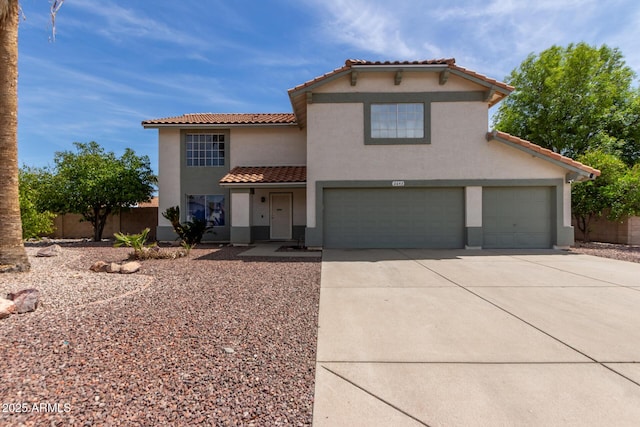 mediterranean / spanish house with an attached garage, a tiled roof, concrete driveway, and stucco siding