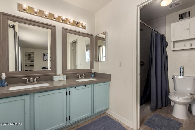full bath featuring double vanity, toilet, curtained shower, and a sink