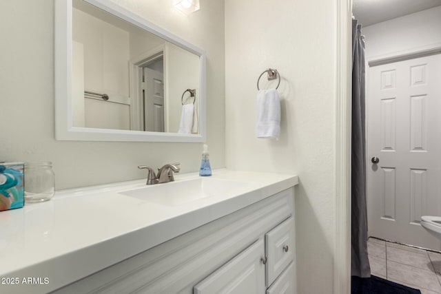 bathroom featuring toilet, tile patterned flooring, and vanity
