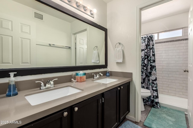 bathroom featuring visible vents, a sink, double vanity, and toilet