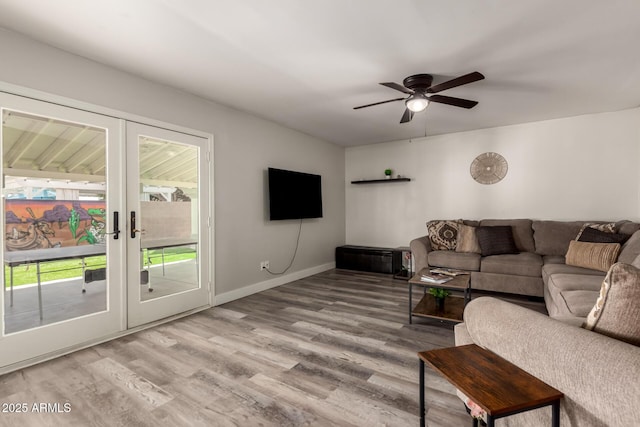 living area with baseboards, a ceiling fan, french doors, and wood finished floors