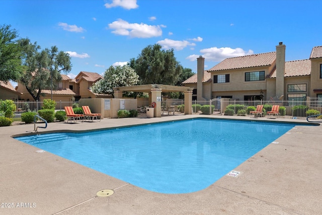community pool featuring fence and a patio area