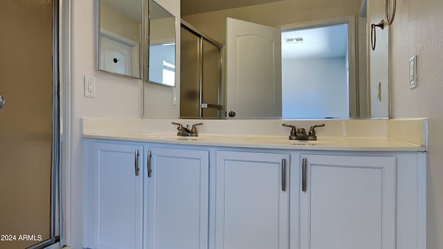 bathroom with vanity and a shower with shower door