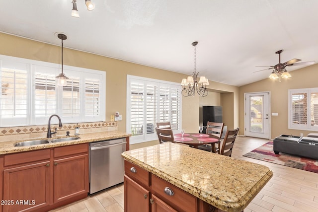 kitchen featuring stainless steel dishwasher, open floor plan, a wealth of natural light, and a sink