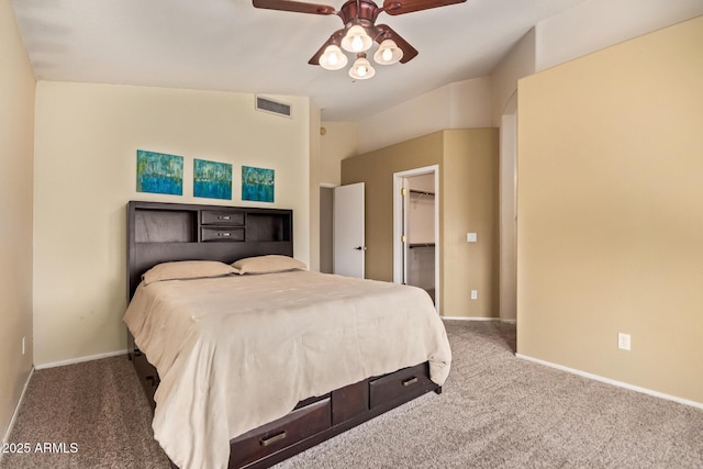 bedroom featuring a ceiling fan, visible vents, carpet floors, baseboards, and a spacious closet
