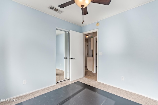 unfurnished bedroom featuring baseboards, carpet, a ceiling fan, and visible vents