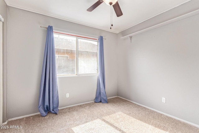 carpeted empty room with baseboards and a ceiling fan