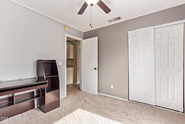 unfurnished bedroom featuring carpet floors, ceiling fan, a closet, and visible vents