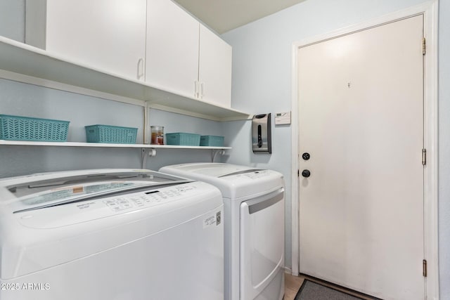 laundry room featuring separate washer and dryer and cabinet space