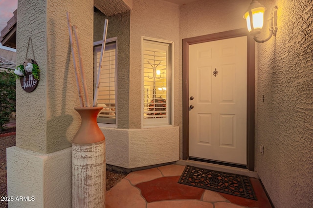 entrance to property featuring stucco siding and a porch