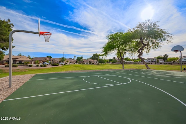 view of basketball court featuring a lawn, community basketball court, and a residential view