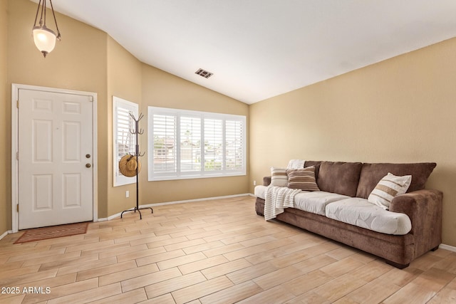 living room featuring baseboards, light wood-style flooring, vaulted ceiling, and visible vents