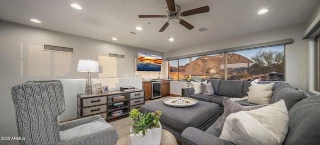 living room with ceiling fan and beverage cooler