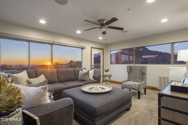 carpeted living room with ceiling fan and a healthy amount of sunlight