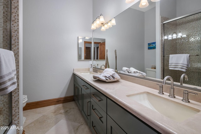 bathroom with a shower with shower door, toilet, and vanity