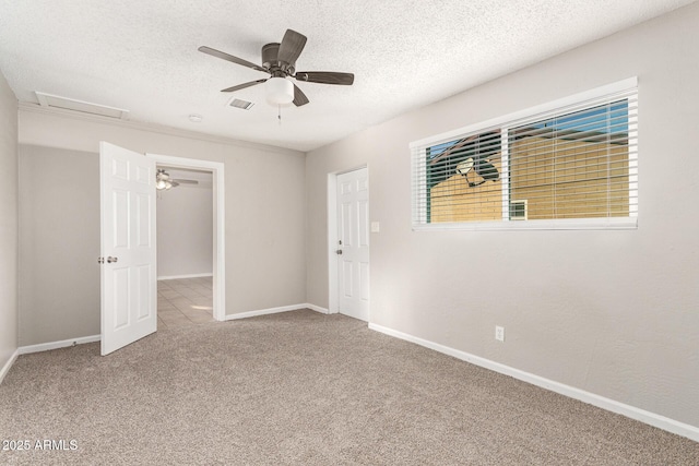 carpeted spare room with ceiling fan and a textured ceiling