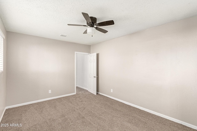 carpeted empty room featuring ceiling fan and a textured ceiling