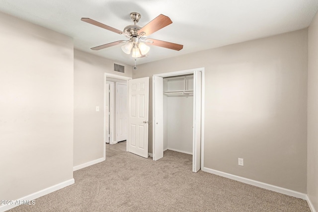 unfurnished bedroom featuring ceiling fan, light colored carpet, and a closet