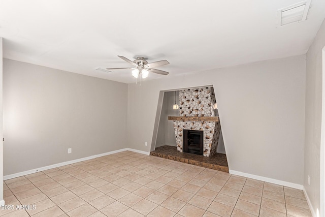 unfurnished living room featuring light tile patterned flooring, a stone fireplace, and ceiling fan