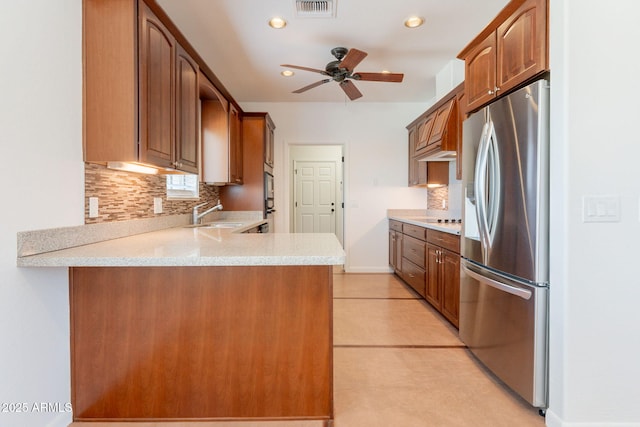 931 E Whiteley St, Apache Junction, AZ 85119 - kitchen featuring stainless steel fridge, a peninsula, a ceiling fan, light countertops, and decorative backsplash