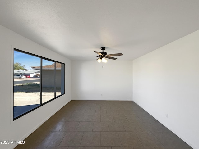 tiled spare room with ceiling fan