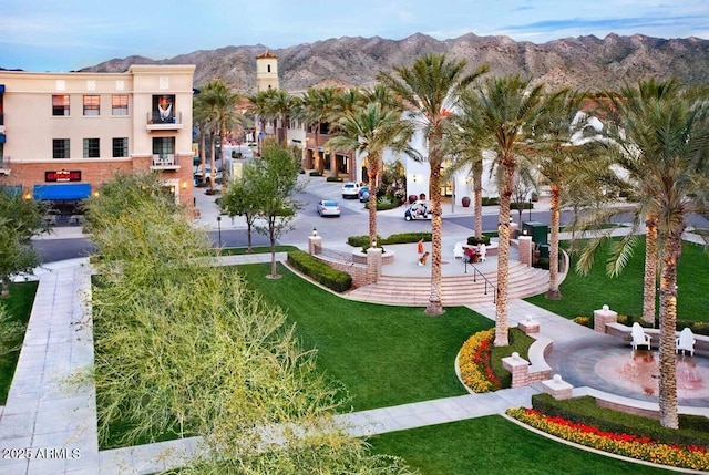 view of community with a mountain view and a lawn