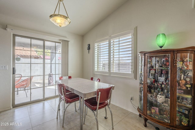 dining area with a healthy amount of sunlight, lofted ceiling, and light tile patterned floors