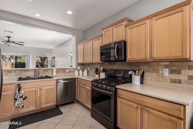 kitchen with light tile patterned floors, light countertops, appliances with stainless steel finishes, and a sink